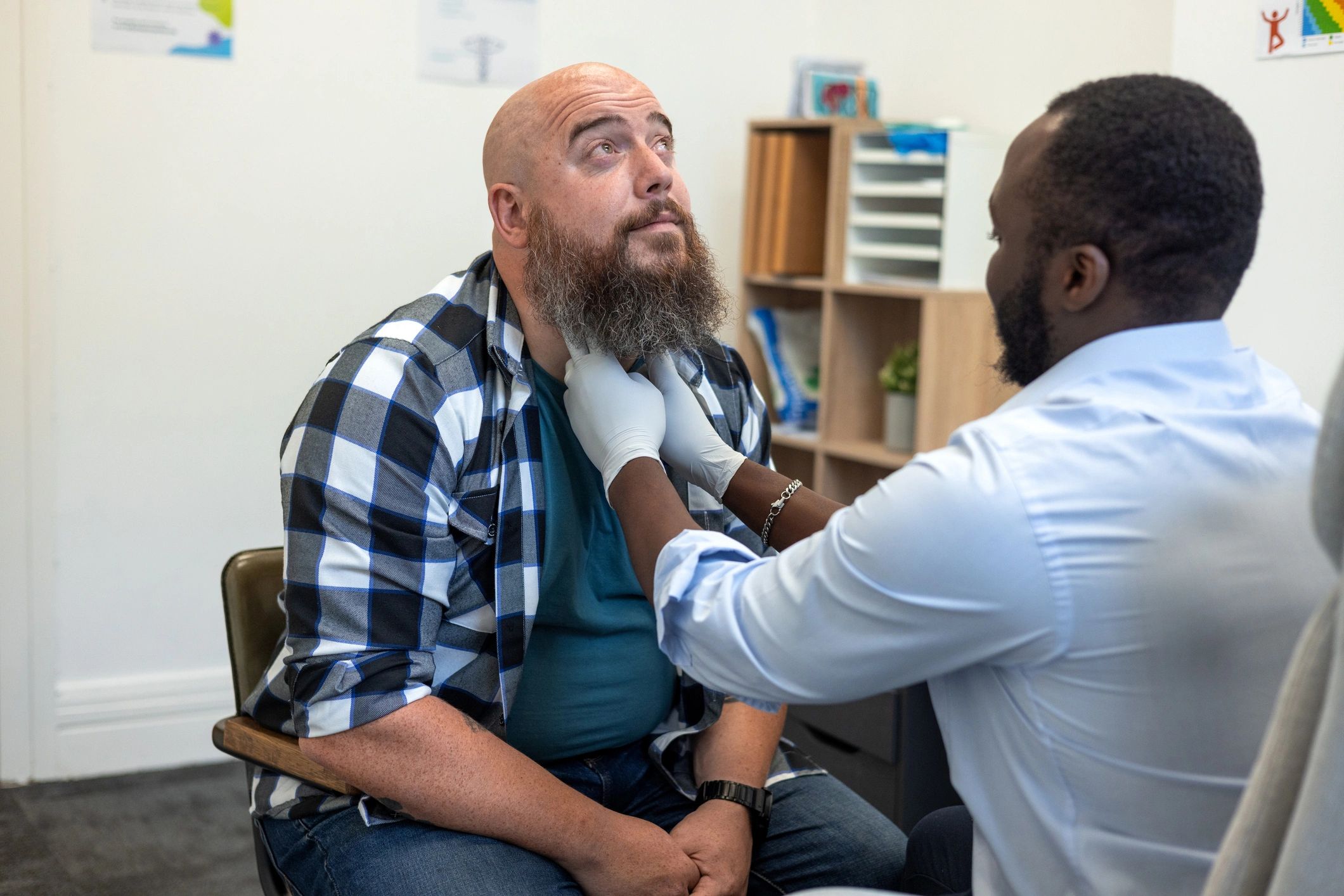 Doctor consulting with a male patient in a private clinic room