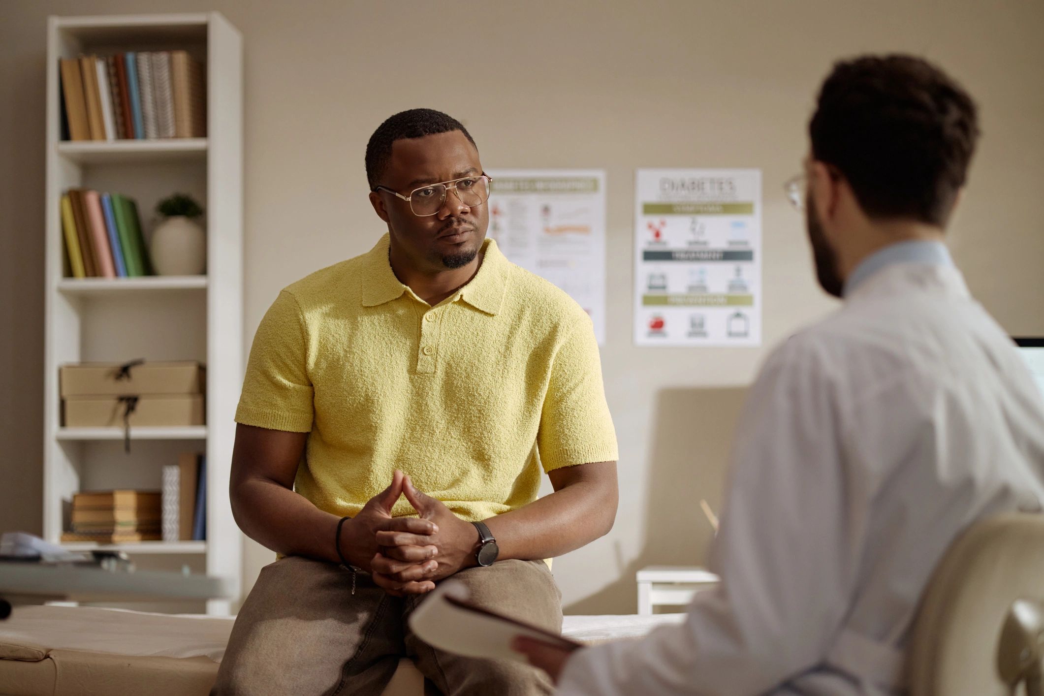 Male patient speaking with a doctor during a clinic consultation
